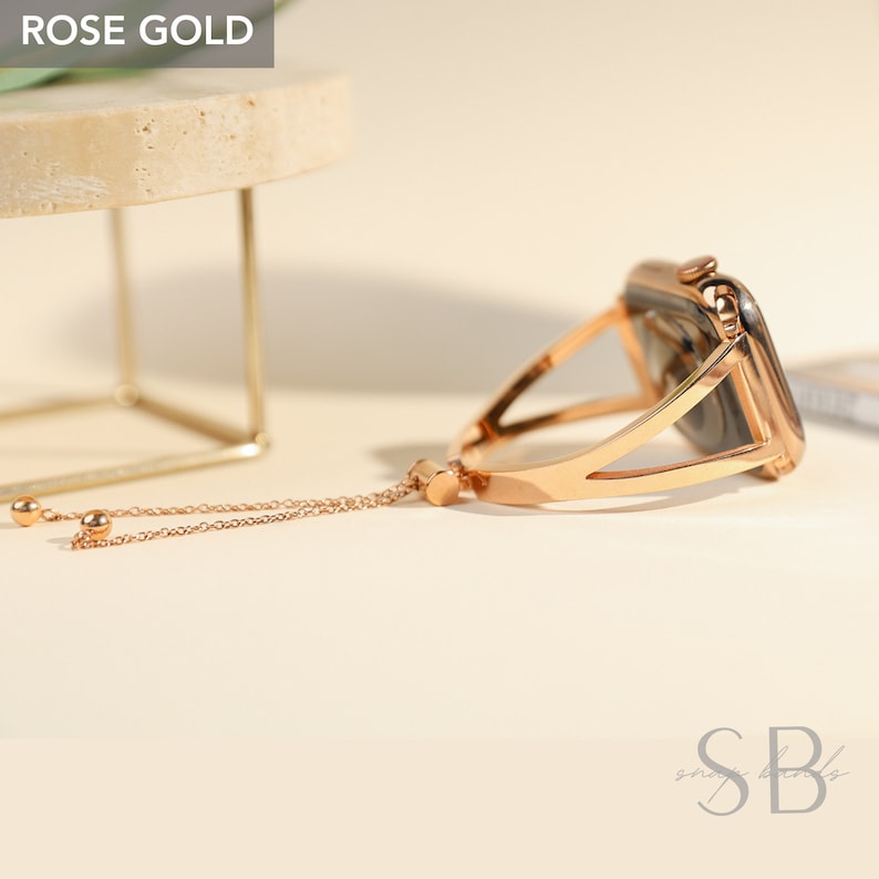 Rose gold Apple Watch band with a chain detail. The band is made of metal and has a sleek, modern design.