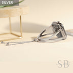 Silver watch band with a chain and beads. The band is designed to fit a square-shaped watch face. The band is made of metal and has a sleek, modern design.