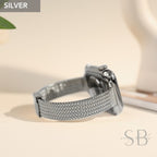 A silver-colored smartwatch with a woven metal band. The watch is displayed on a light-colored surface, with the word "SILVER" in a gray box in the upper left corner.