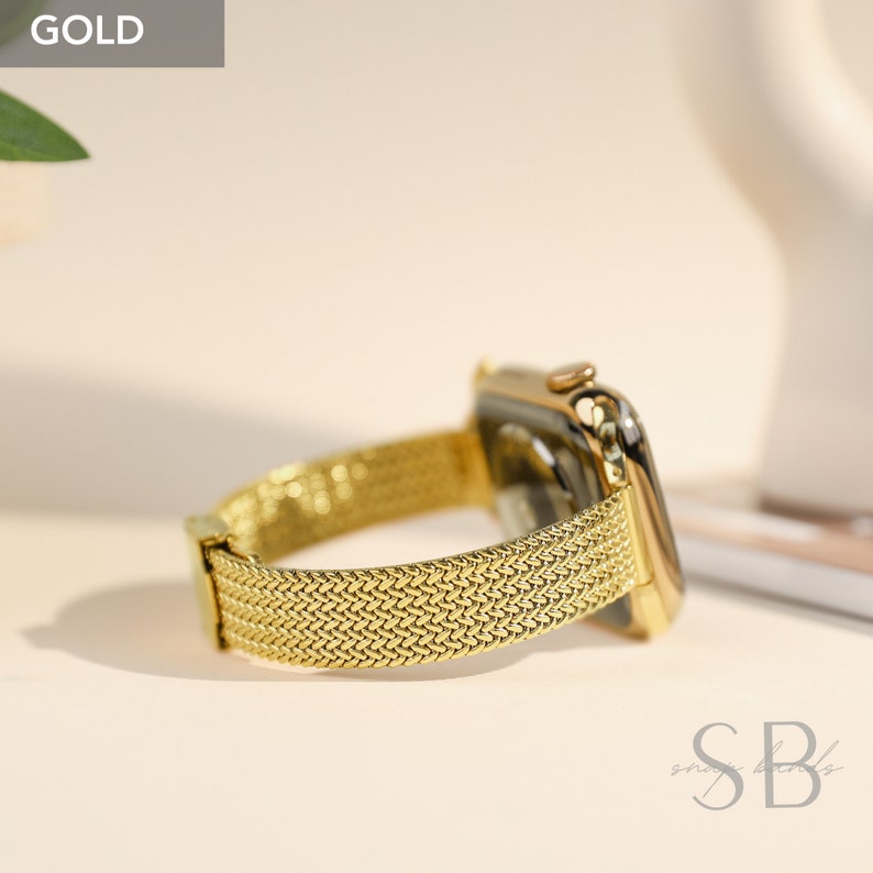 A gold-colored smartwatch with a mesh band. The watch face and band are a matching gold color. The band has a woven texture. The word "GOLD" is in the upper left corner.