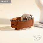 A brown leather watch band with a silver buckle and stitching. The band is designed for an Apple Watch.