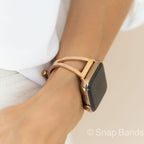 A gold-toned metal watch band with a geometric design. The band is designed to fit a smartwatch.
