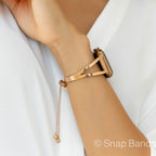 A gold-toned metal watch band with a triangular design and a chain strap. The band is designed to fit a smartwatch.