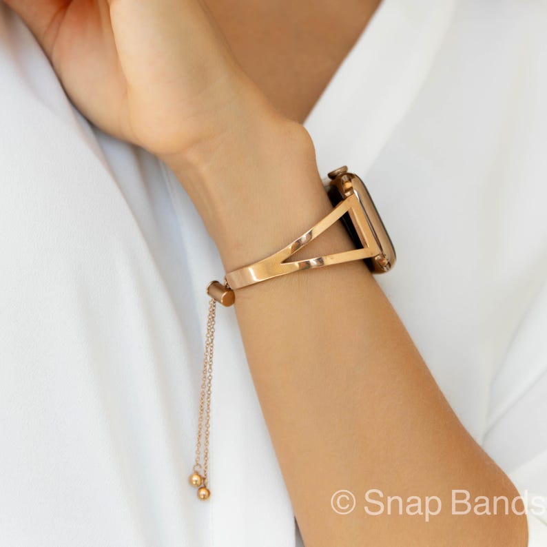 A gold-toned metal watch band with a triangular design and a chain strap. The band is designed to fit a smartwatch.