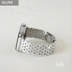 Silver-colored watch with a woven metal band. The watch face is rectangular with a silver finish. The band is made of small, rectangular links. The word "SILVER" is in a gray box in the upper left corner.