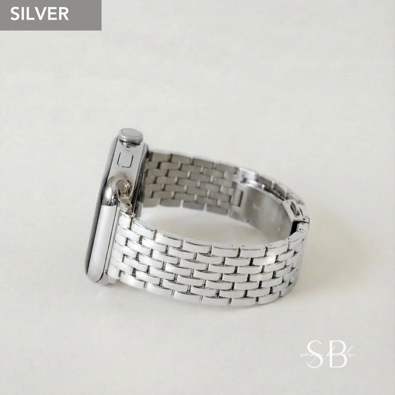Silver-colored watch with a woven metal band. The watch face is rectangular with a silver finish. The band is made of small, rectangular links. The word "SILVER" is in a gray box in the upper left corner.